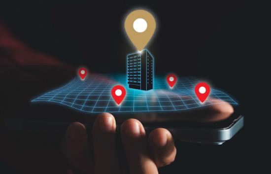 Hand holding phone with GPS location pins for building