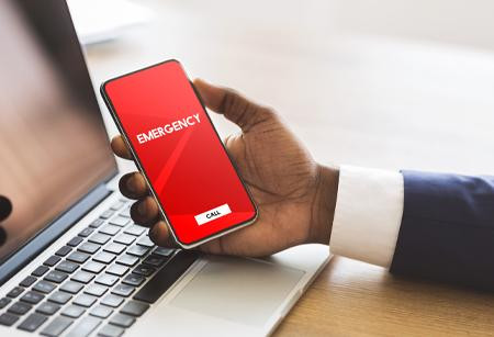 Man holding phone with the words "Emergency" on it